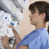 Female nurse standing at shelf with medicinal supplies